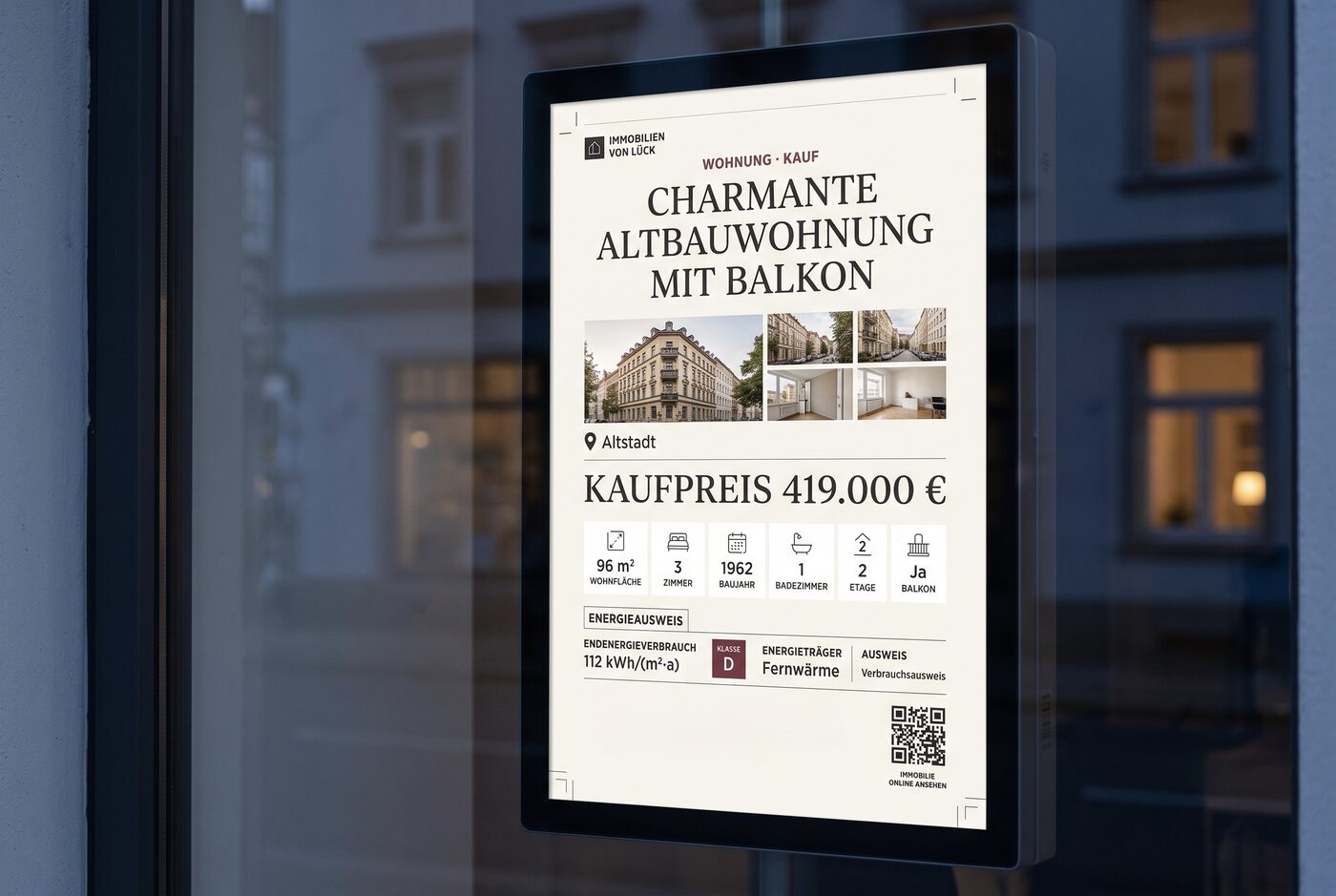 Nahaufnahme eines digitalen Exposé-Aushangs auf einem Schaufenster-Monitor: Objektfoto, Kaufpreis, Eckdaten und die GEG-Pflichtangaben mit Energieausweis-Klasse und QR-Code.